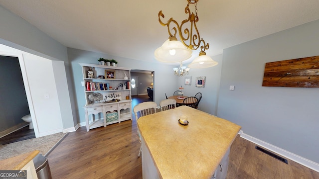 dining room with baseboards, visible vents, dark wood finished floors, and a notable chandelier