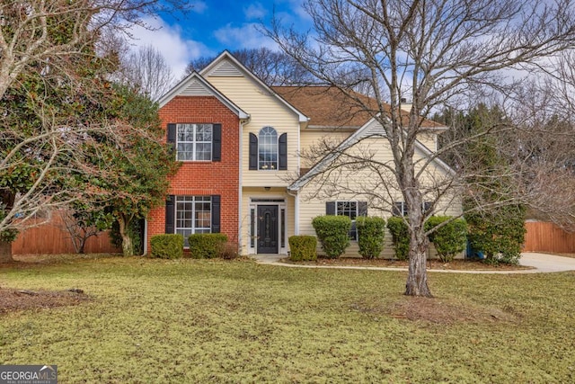 traditional-style home featuring brick siding, fence, and a front yard