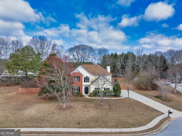 traditional-style home featuring a chimney and concrete driveway