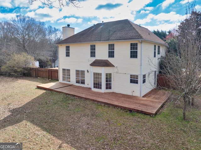 back of house with a yard, a chimney, fence, and a wooden deck