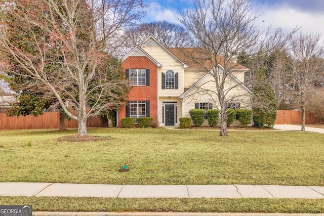 traditional home with brick siding, fence, and a front lawn