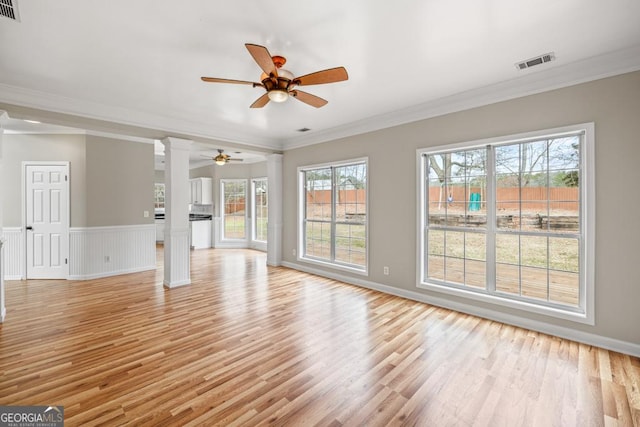 unfurnished living room featuring visible vents, crown molding, and light wood finished floors