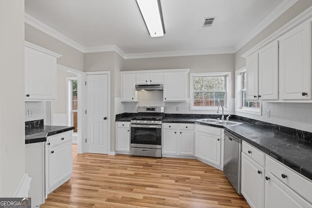 kitchen with under cabinet range hood, white cabinetry, stainless steel appliances, and a sink