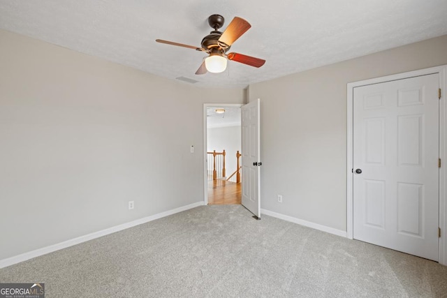 unfurnished bedroom with light carpet, visible vents, baseboards, ceiling fan, and a textured ceiling