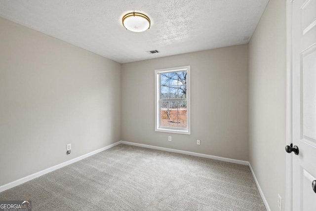 carpeted empty room featuring a textured ceiling, visible vents, and baseboards