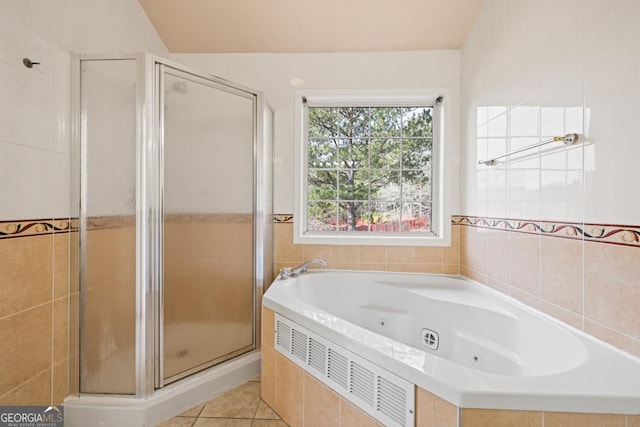 bathroom with a whirlpool tub, a stall shower, and tile patterned flooring