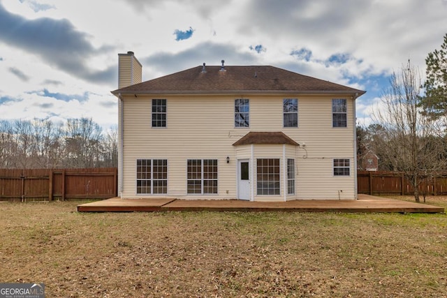 back of property featuring a fenced backyard, a lawn, and a deck