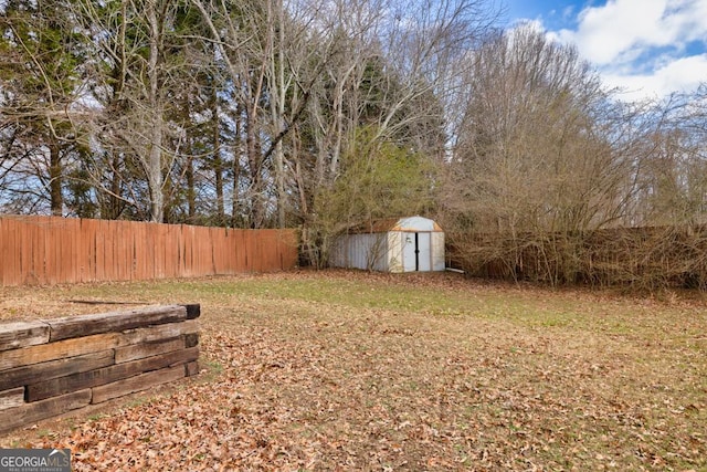 view of yard featuring a fenced backyard, an outdoor structure, and a shed