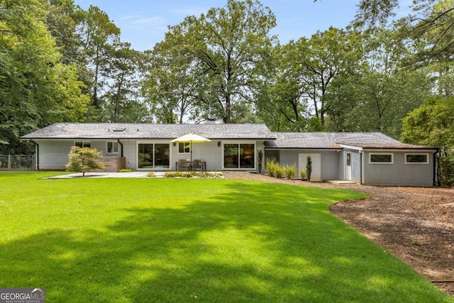 view of front of home with a front yard, fence, and a patio