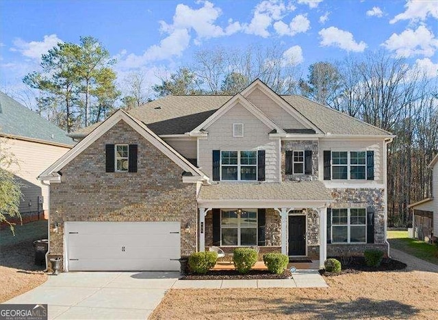 craftsman-style home featuring covered porch, brick siding, driveway, and an attached garage