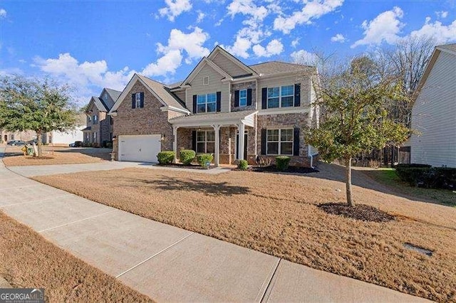 view of front of house featuring a garage, driveway, a porch, and a front yard