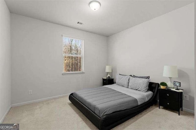 bedroom with baseboards, visible vents, and light colored carpet