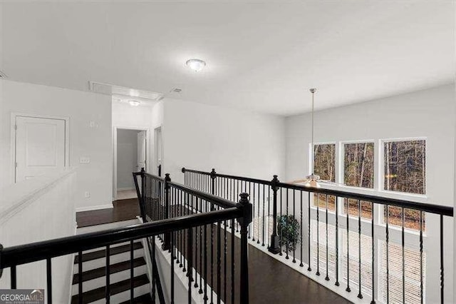 hall featuring baseboards and an upstairs landing