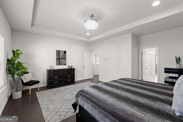 bedroom featuring recessed lighting, a raised ceiling, dark wood finished floors, and baseboards