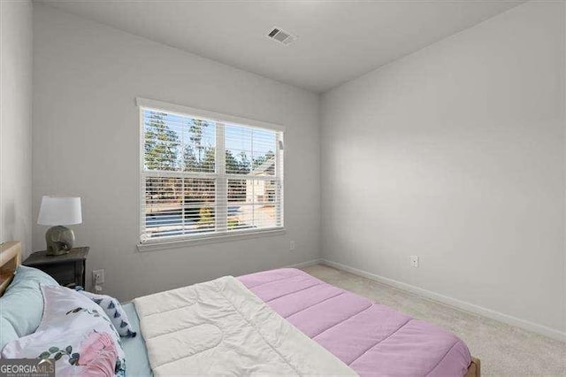 bedroom with visible vents, light carpet, and baseboards