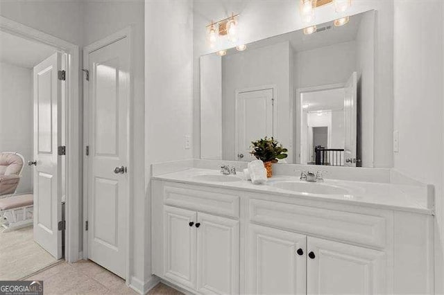 bathroom with double vanity, a closet, and a sink