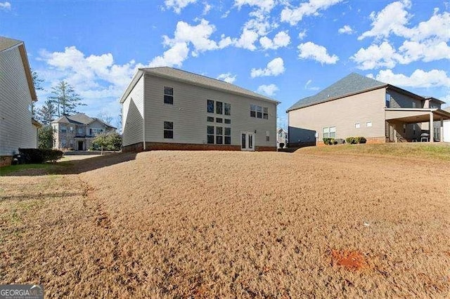 rear view of property with a lawn