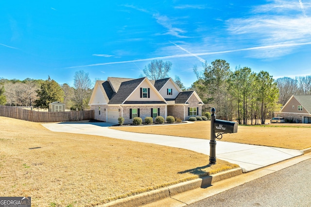 view of front of property with an attached garage, driveway, a front yard, and fence