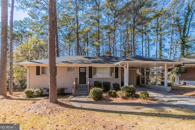 ranch-style house featuring crawl space, driveway, an attached carport, and brick siding