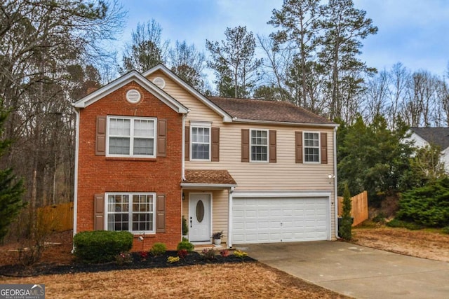 traditional-style home featuring an attached garage, fence, concrete driveway, and brick siding