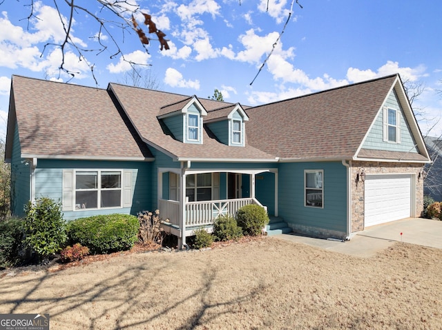 cape cod-style house with covered porch, a shingled roof, and concrete driveway