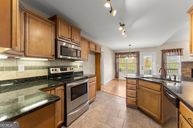 kitchen with plenty of natural light, tasteful backsplash, appliances with stainless steel finishes, and a sink