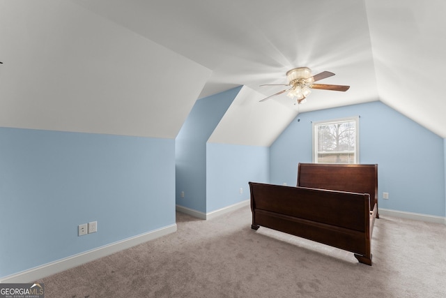 bedroom featuring ceiling fan, baseboards, vaulted ceiling, and light colored carpet