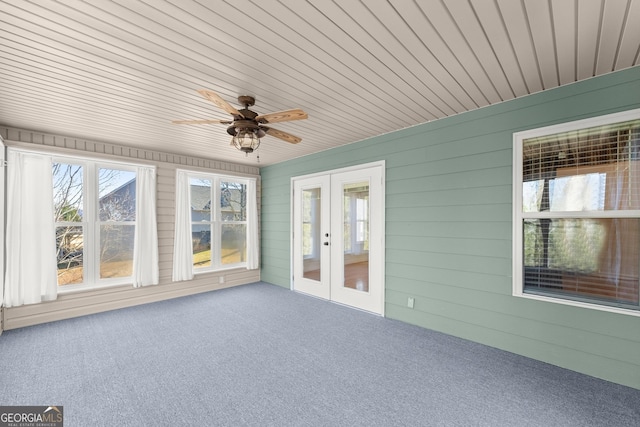 unfurnished sunroom featuring wooden ceiling, ceiling fan, and french doors