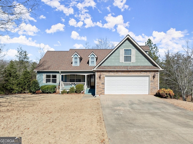 view of front of home with stone siding, covered porch, and concrete driveway