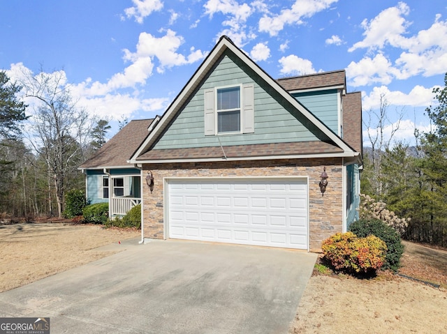 view of front of property with a garage, concrete driveway, a shingled roof, and stone siding