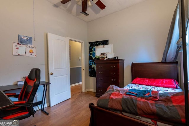 bedroom with light wood-style floors, baseboards, and a ceiling fan