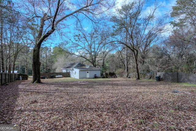 view of yard featuring an attached garage and fence