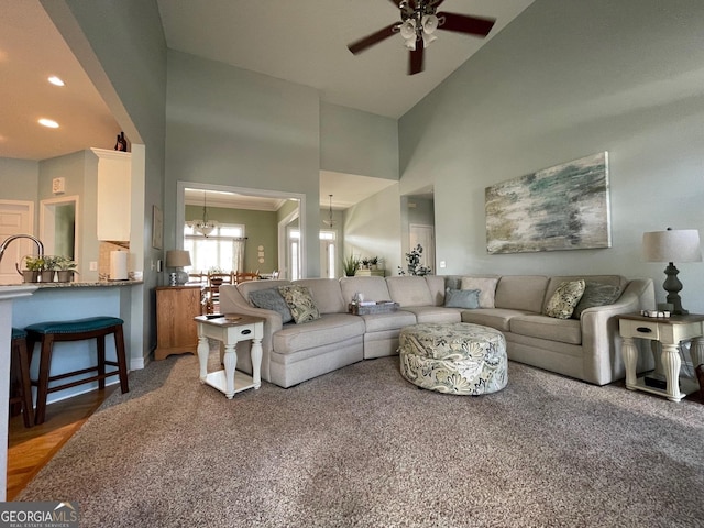 living area with recessed lighting, a towering ceiling, and ceiling fan with notable chandelier