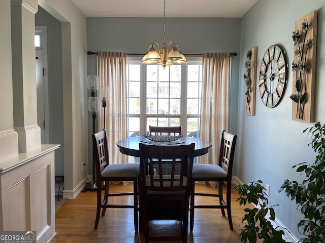 dining area with dark wood-style floors, a notable chandelier, and baseboards