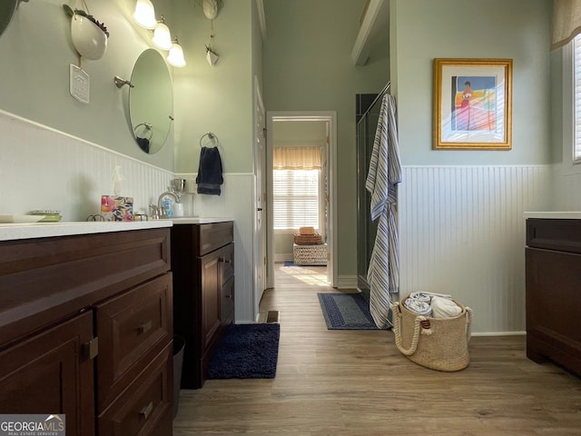 bathroom featuring a wainscoted wall, wood finished floors, and vanity