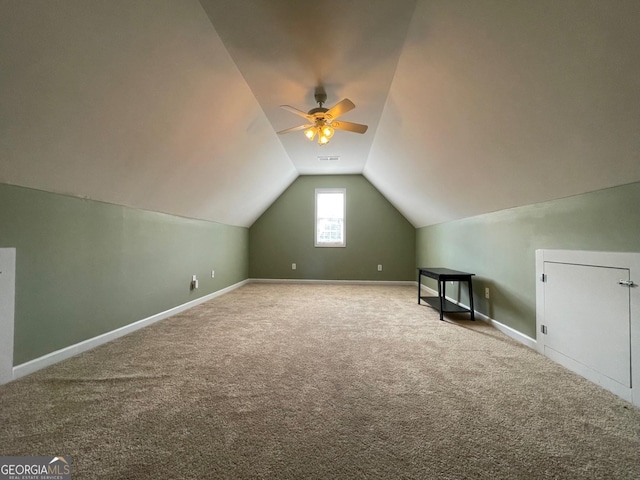 additional living space with carpet floors, a ceiling fan, visible vents, vaulted ceiling, and baseboards