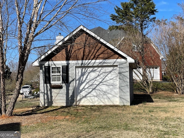 view of property exterior featuring a garage, a chimney, an outdoor structure, and a lawn