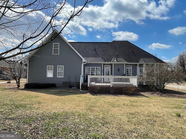 back of property with cooling unit, a lawn, and a deck