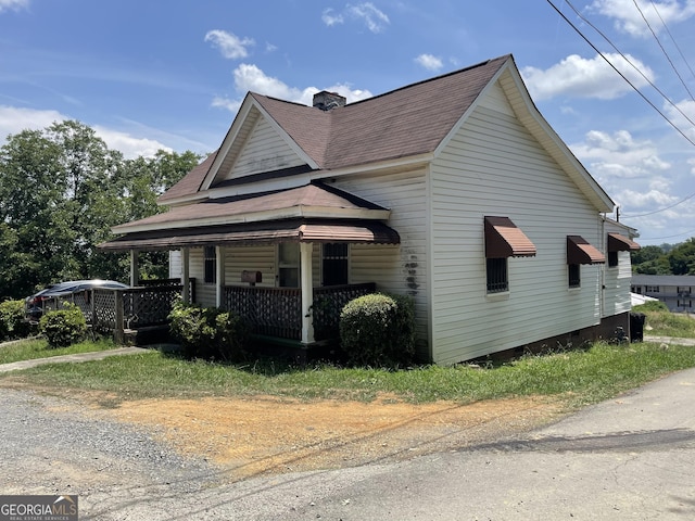 view of front of property featuring covered porch and a shingled roof