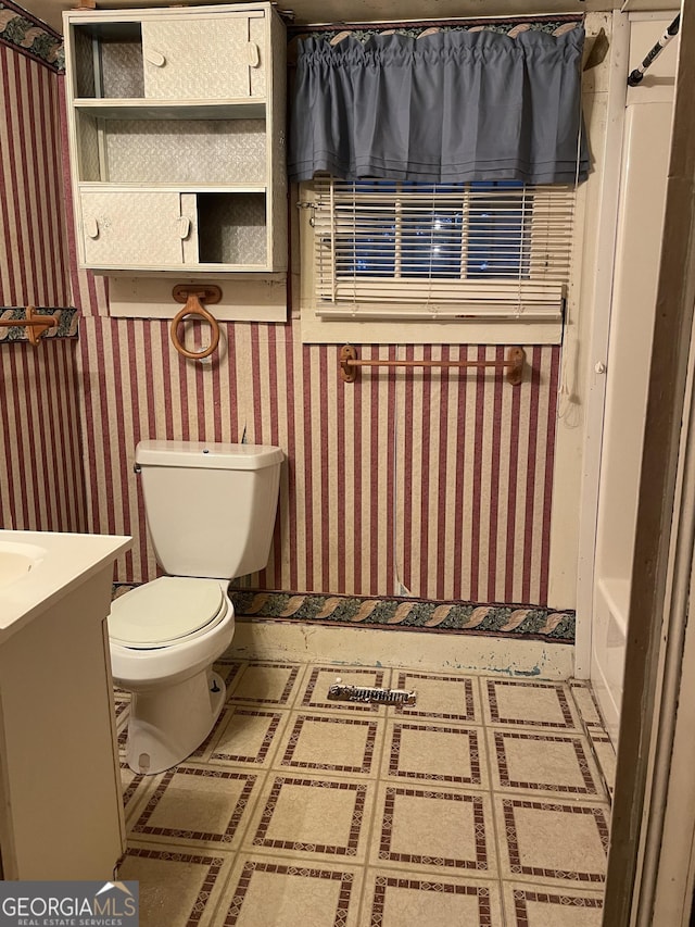 full bath featuring tile patterned floors, vanity, toilet, and wallpapered walls