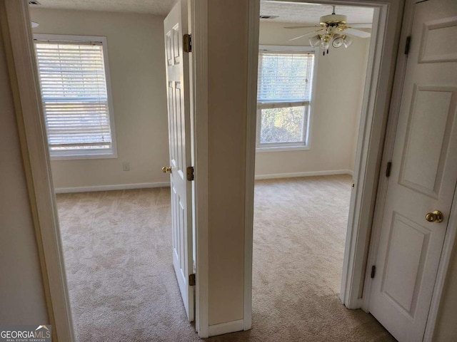 hallway with light carpet and baseboards