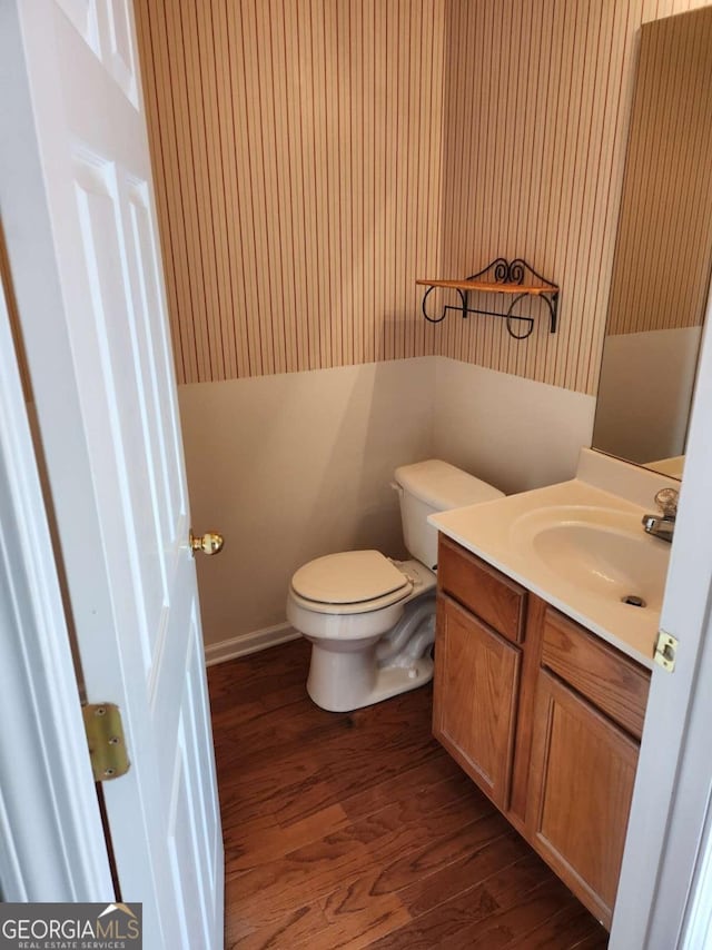 bathroom featuring toilet, wood finished floors, and vanity