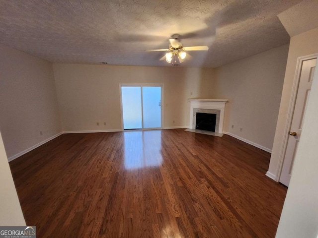 unfurnished living room featuring dark wood-style flooring, a fireplace, a ceiling fan, a textured ceiling, and baseboards