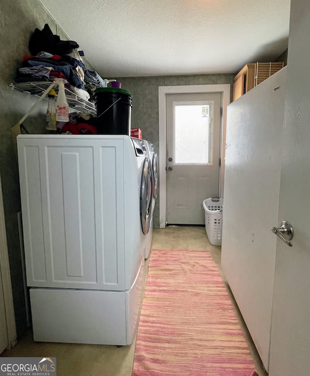 laundry room with laundry area, washing machine and dryer, and a textured ceiling