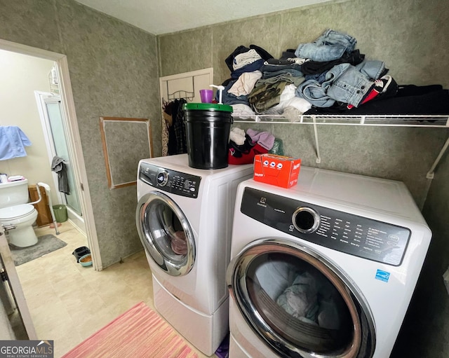 clothes washing area with washing machine and dryer