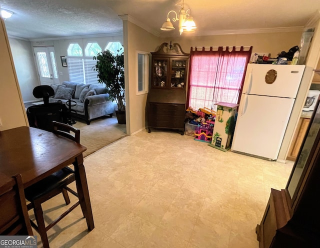 dining room featuring ornamental molding, a chandelier, a textured ceiling, and tile patterned floors