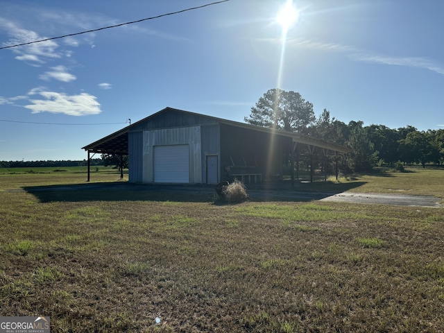 view of pole building with driveway and a lawn