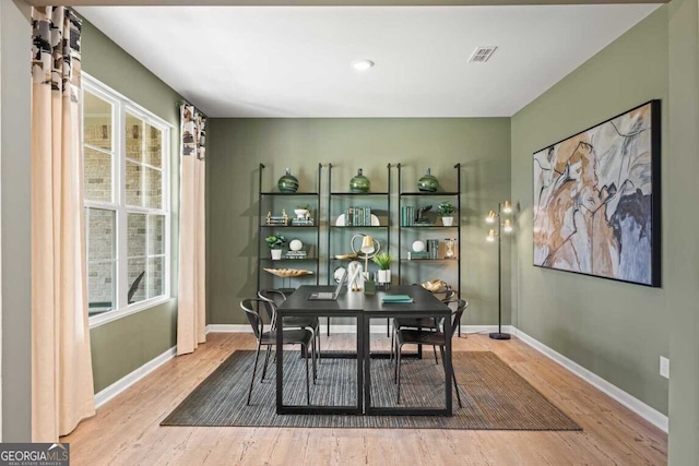 dining space featuring wood finished floors, visible vents, and baseboards