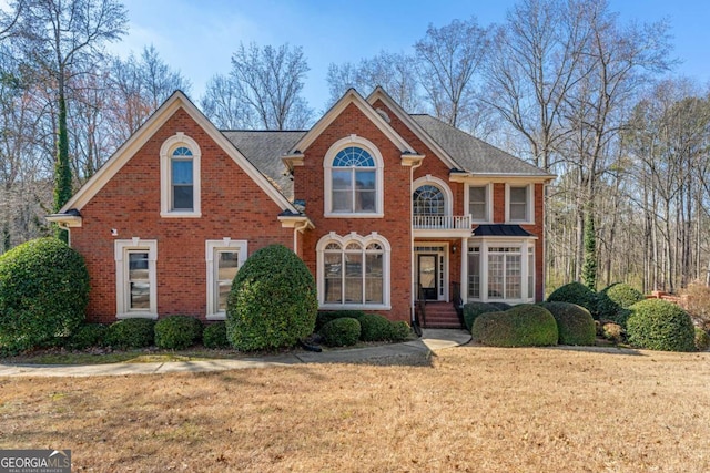 view of front facade with brick siding and a front lawn