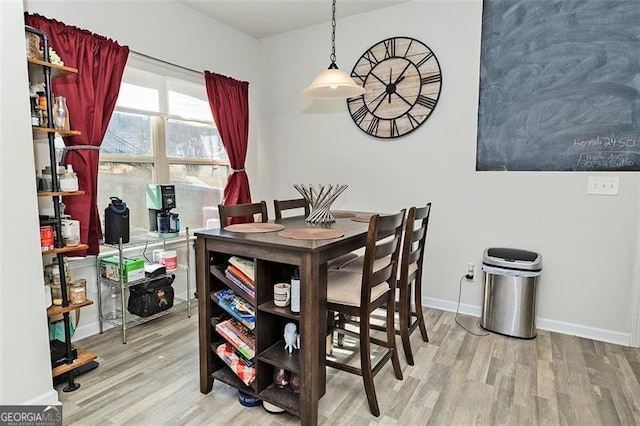 dining space featuring baseboards and light wood finished floors